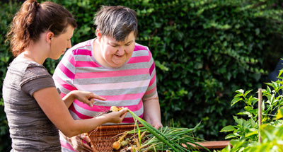A carer helping a patient in the garden