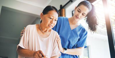 A carer helping an elderly patient