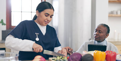 A carer cooking for an elderly patient