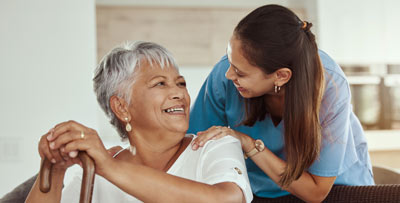 A carer smiling at an elderly woman