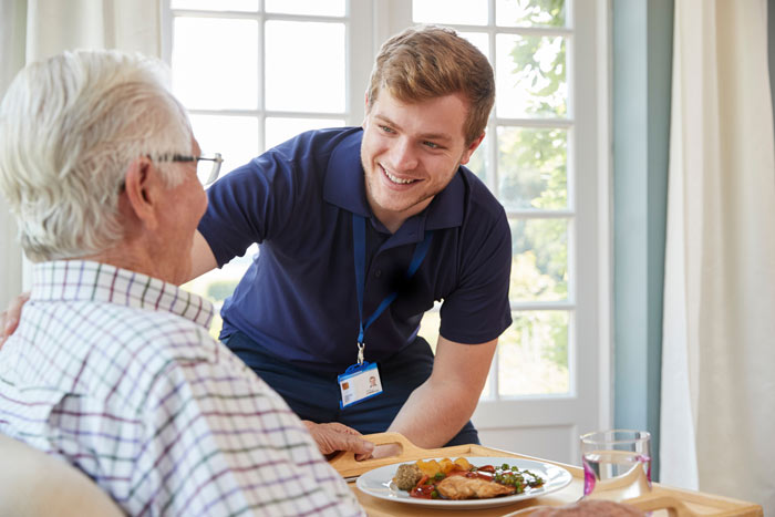 A carer smiling at an elderly man