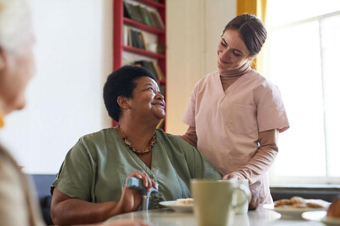 A carer helping an elderly woman
