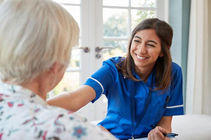 A carer smiling at an elderly patient